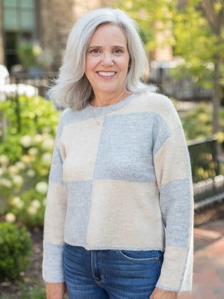 a chunky fall sweater with pale blue and cream color block squares that crops at the waist