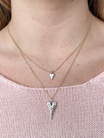 mixed-metal heart pendant necklace with two dainty gold chains featuring two abstract silver heart charms