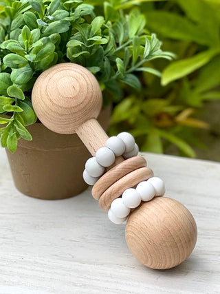 gray and white beech wood baby rattle with food grade silicone is a gentle teething toy for your toddler or infant to hold
