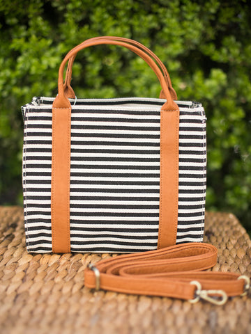 handbag with top handles black and white stripes and removable crossbody strap trimmed with vegan leather