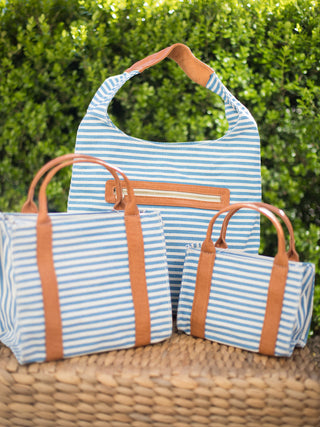 handbag with top handles blue and white stripes and removable crossbody strap trimmed with vegan leather group