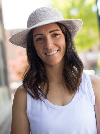 a crushable half brim sun hat in light beige with upf 50 and an interior adjustable velcro band shown on model