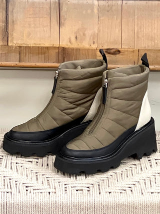a pair of olive apres ski snow boots made of puffy nylon with a top zipper closure and a chunky black lug sole