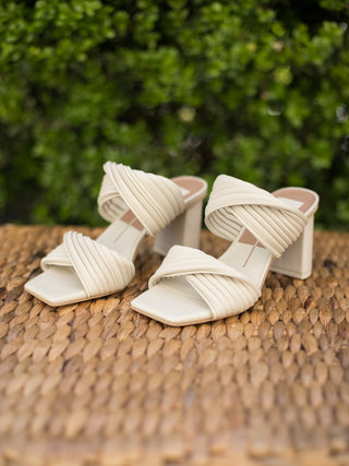 sleek ivory sandal with wide twisted vamp straps block heel and square toe