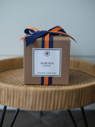 a gift box with orange and navy blue ribbon and auburn alabama printed on the side