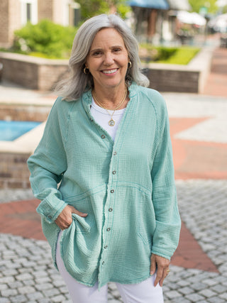 teal green breezy cotton tunic button down shirt with v-neckline and frayed edges is made of 100% cotton
