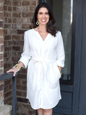woman wearing lightweight white cotton gauze button down shirt dress with three-quarter sleeves and self tie belt