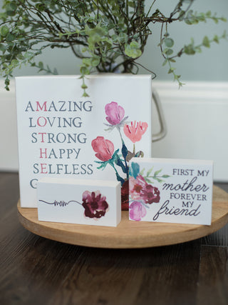 a collection of white block art displays with watercolor flowers and messages to mom