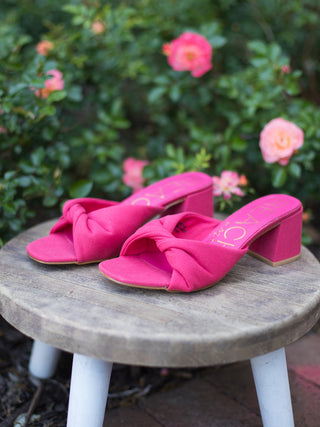 hot pink sandals with a slip on style featuring a knotted design and block heel