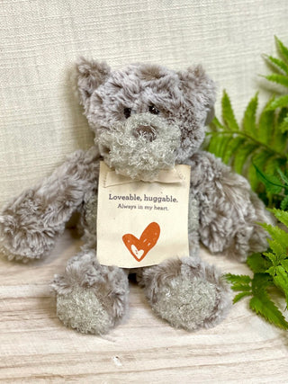 velvety soft gray stuffed bear with a bookmark hangtag that says loveable huggable always in my heart for a sentimental gift