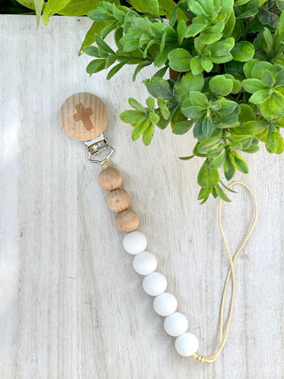 baby pacifier clip with food grade white silicone and teething friendly beech wood beads has a cross and cotton string loop