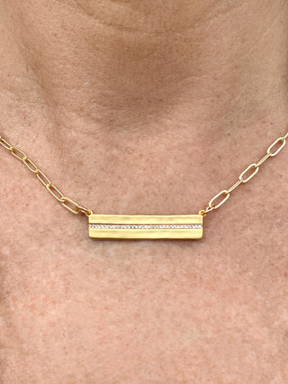 gold bar necklace with row of dainty rhinestones and gold paperclip chain close up