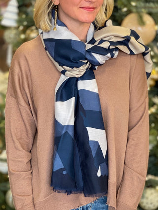 a blue and white scarf with multicolored patterns perfect to wrap around your neck or drape across your shoulders