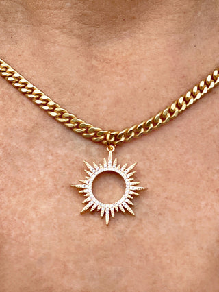 medium-sized gold curb chain necklace with striking rhinestone sun starburst pendant close up