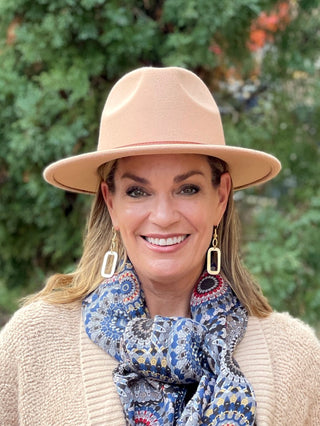 a beige wide brimmed hat with a tan faux leather band across the top great for fall and winter accessorizing 